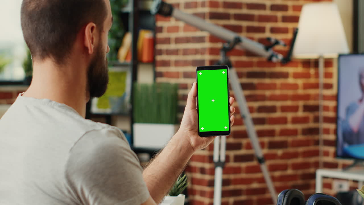 Office worker analyzing smartphone with greenscreen template