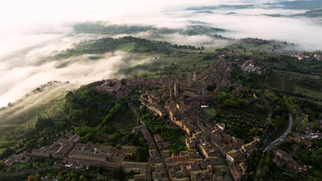 early morning mist over medieval hill town of san gimignano in siena, tuscany, north-central italy