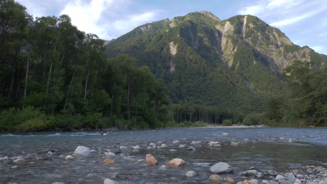 Azusa-floden, der strømmer forbi tæt skov og tårnhøje Hotaka-bjerge i Kamikochi, Nagano, Japan. Vidvinkeloptagelse.