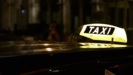 segnale di illuminazione del taxi in arrivo mentre il taxi parcheggia in città di notte