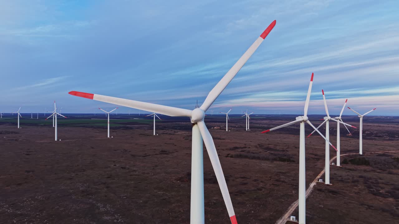 Turbine eoliche in un campo durante il tramonto con cielo nuvoloso