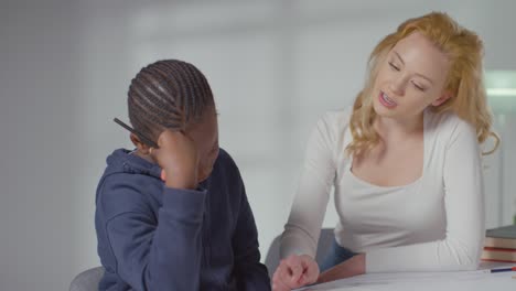 niño en el espectro del tda en casa siendo ayudado o evaluado por una tutora doméstica o una psicóloga educativa 1