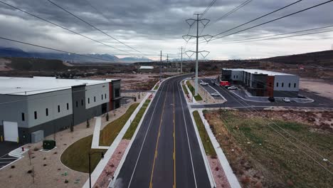 Aerial-Shot-Going-Between-Power-Lines-and-Warehouses-at-Bringhurst-Station-in-Bluffdale-Utah