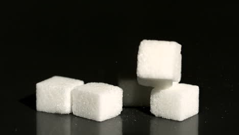 sugar cube falling on black surface