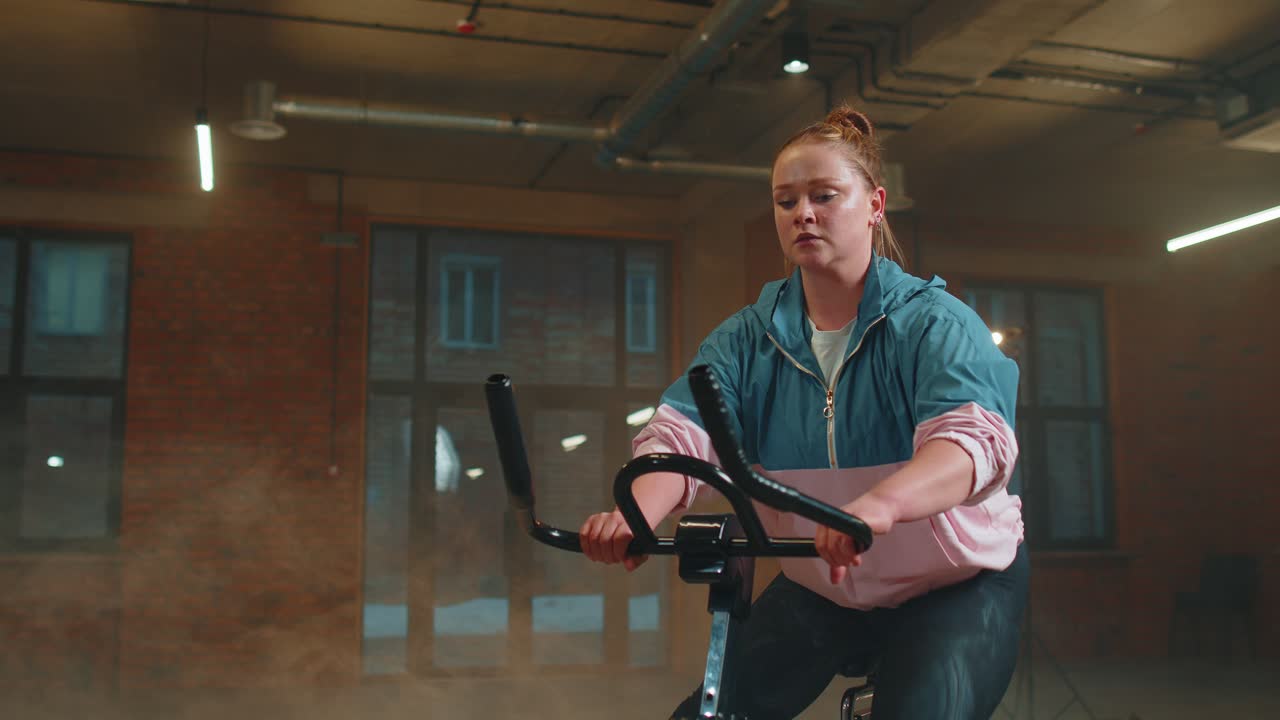 Woman performs aerobic endurance training workout cardio routine on the simulators cycle training