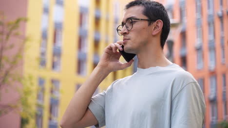 Serious-Young-Japanese-Man-Talking-On-The-Mobile-Phone-While-Standing-Outdoors-In-The-Street-2