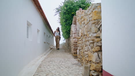 romantic girl walking vacation town vertical. urban traveler stroll old street