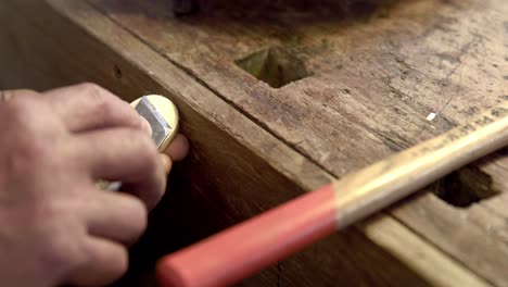 lutier trabajando en una pequeña pieza de violín.