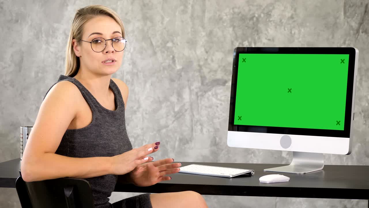 joven atractiva con gafas hablando a la cámara. pantalla verde muestra de maqueta