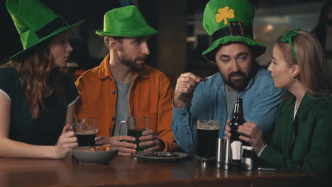 amigos em chapéus irlandeses comemorando o dia de são patrício em um pub 2