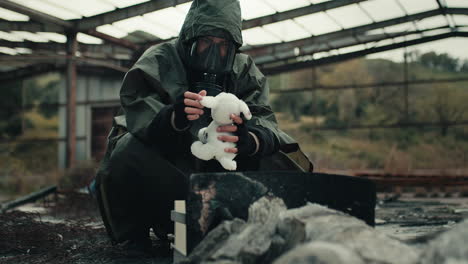 man with soft toy in apocalyptic site