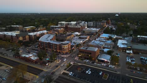 aerial capture of downers grove illinois at dusk featuring illuminated streets and urban landscape. orbit left dusk s