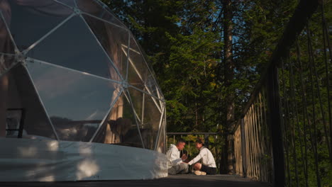 man practices meditation with lady coach near glamping tent. guy immerses in meditation session guided by female yoga instructor at retreat resort