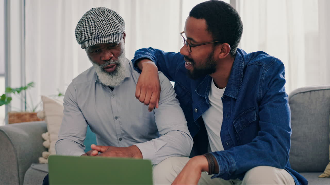 高齢の父と息子がラップトップで見ている