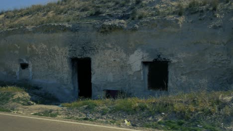 A-shot-of-two-houses-carved-into-the-rock-near-a-road