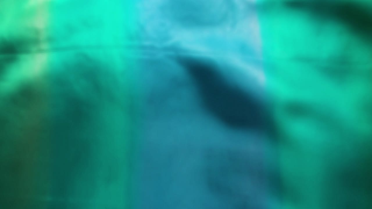 и синяя шелковая ткань течет зеленый дует на ветру в замедленном движении фоновой текстуры