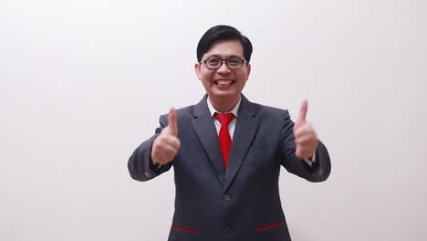 asian businessman standing while presenting both sides and showing thumbs up and fist hands