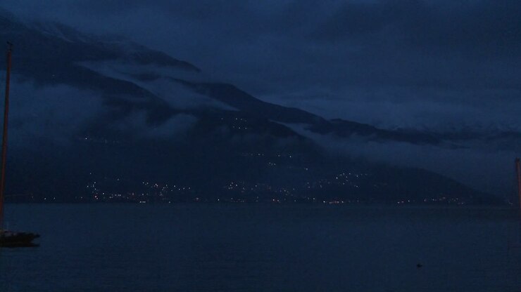 Una barca attraversa un lago buio di notte