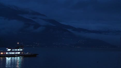 a boat crosses a dark lake at night