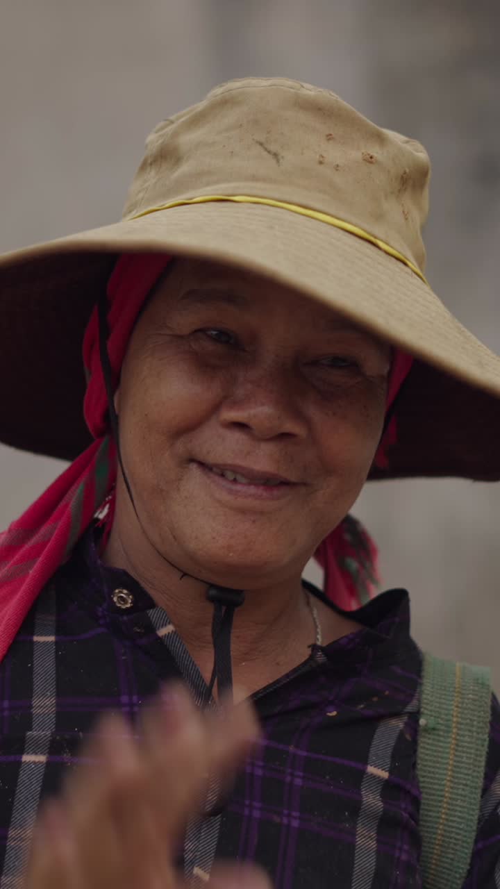 Portrait of an older woman wearing a hat and headscarf