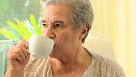 Pensive-mature-woman-drinking-tea
