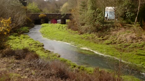 Weitwinkelaufnahme-Des-Flusses-Carnon-Mit-Straßenbrücke-Und-Sonneneruption