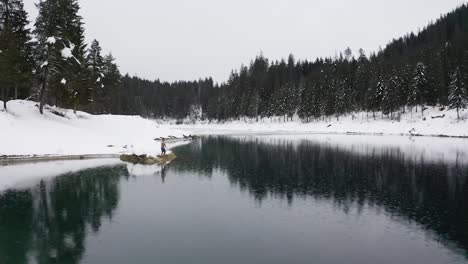 toma aérea de un joven saltando al agua helada de caumalake, suiza