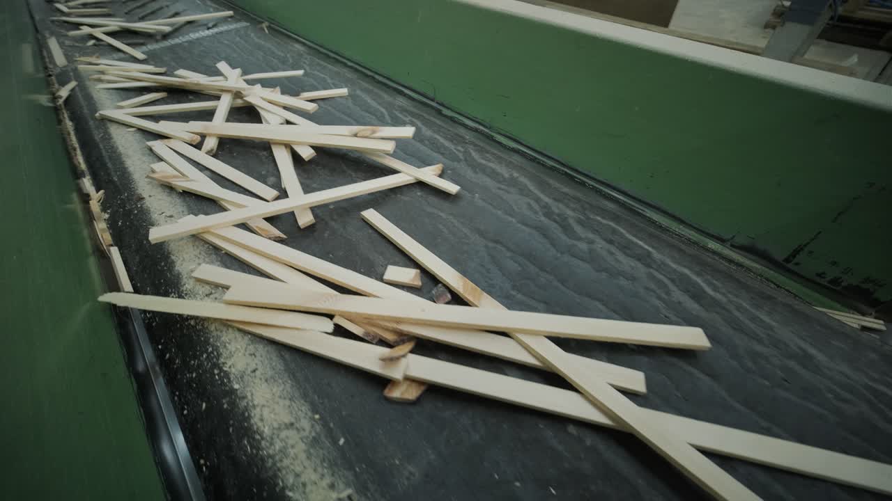 Scarti di legno che si muovono su un nastro trasportatore in una fabbrica