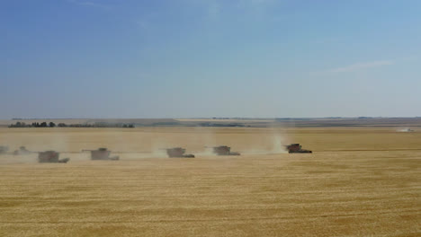 farmers on combine harvester working and harvesting grain crops at daytime in canada