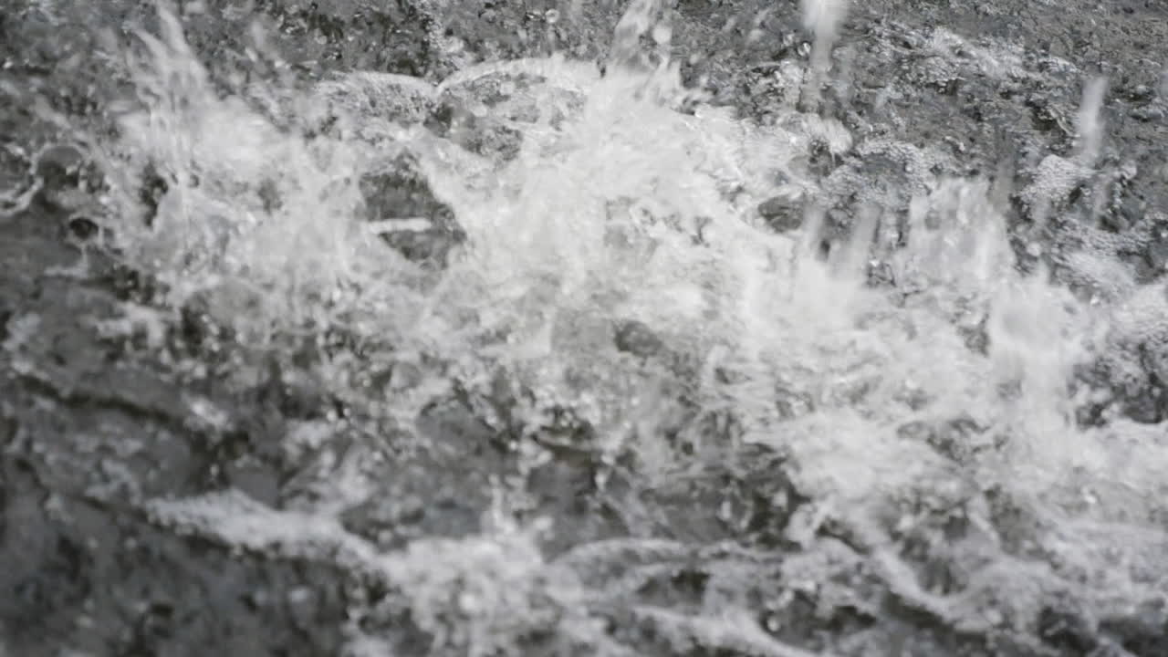 A close-up of splashing water in slow motion, showcasing turbulent ripples, frothy textures, and dynamic energy for nature-themed visuals.