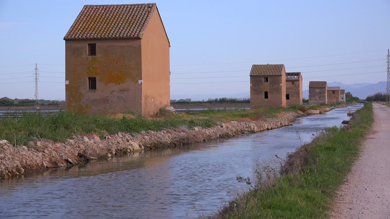 Insolite capanne quadrate di adobe lungo un canale di irrigazione vicino all'Albufera, Spagna
