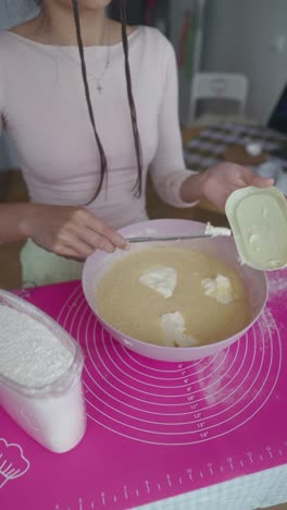 una mujer horneando un pastel.