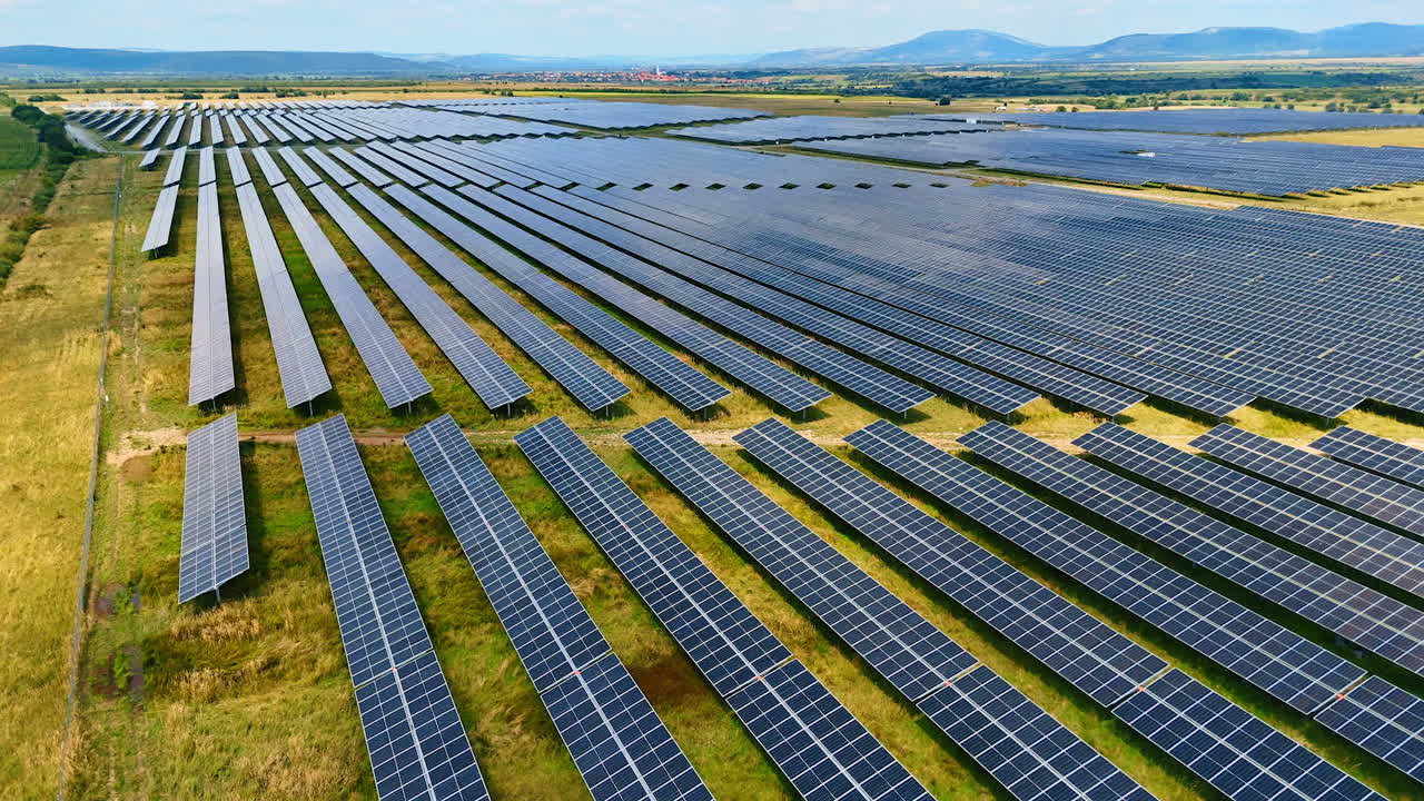 Flight along the field with installed numerous photovoltaic panels. Solar panels accumulate sunlight in the countryside