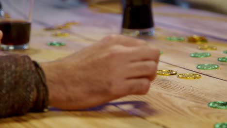 close up of friends at home or in bar celebrating at st patrick's day party drinking alcohol and playing with novelty gold coins 2