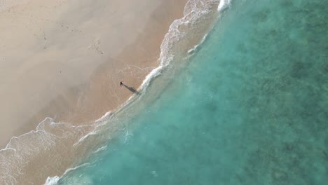 Woman-walking-into-crystal-clear-water-on-Gili-Meno-Island-during-holidays