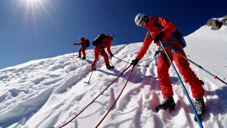 team of mountaineers climbing a snow-covered slope