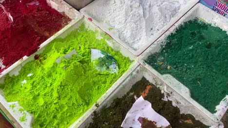 top view of colorful traditional happy holi powder in bowls sold in local market in india