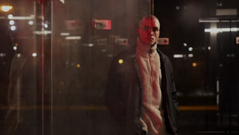 urban man in glasses reflected in glass at night