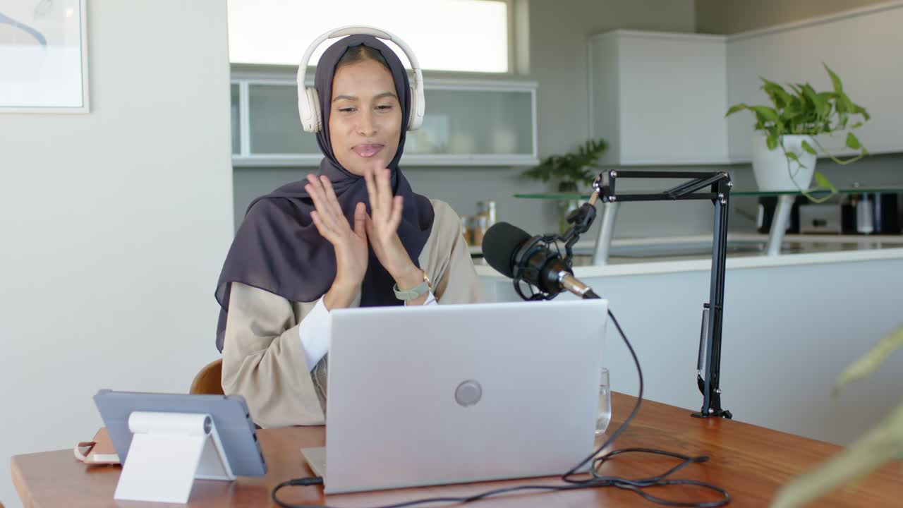 Adult woman hijab headset starting recording, hosting meeting laptop mic, moving talking, clapping