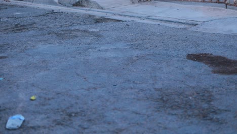 vista panorámica derecha de una calle mexicana llena de baches y basura durante el atardecer