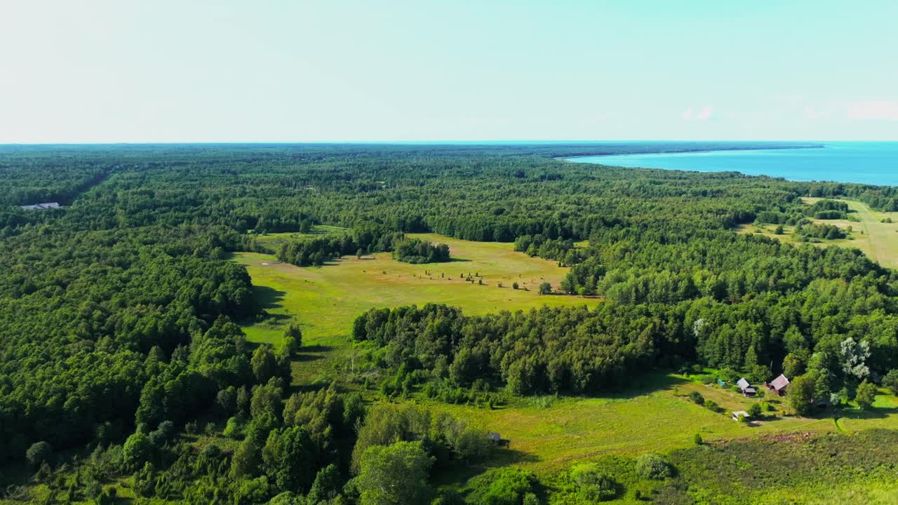 Flying and descending towards a clearing in the forest. Coast and sea visible in the distance.