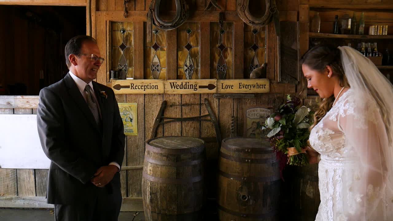 Atlanta, GA - November 21, 2018: A father gets a first look at his daughters beautiful white wedding dress on her special day at a rustic rural farm in the country.