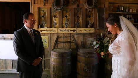 atlanta, ga - november 21, 2018: a father gets a first look at his daughters beautiful white wedding dress on her special day at a rustic rural farm in the country.