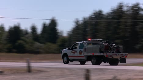 emergency personnel race down a highway in a rural area