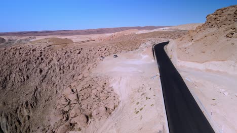 aerial of a car in the road in atacama desert, chile - forward, drone shot