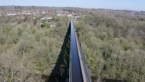 a cyclist walking across the beautiful narrow boat canal route called the pontcysyllte aqueduct famously designed by thomas telford, located in the beautiful welsh countryside, bridge