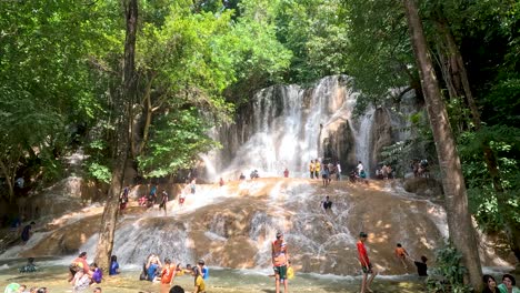 personas relajándose y jugando cerca de una cascada