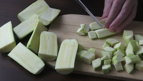 woman holding kitchen knife, chopping peeled zucchini. healthy eating concept.