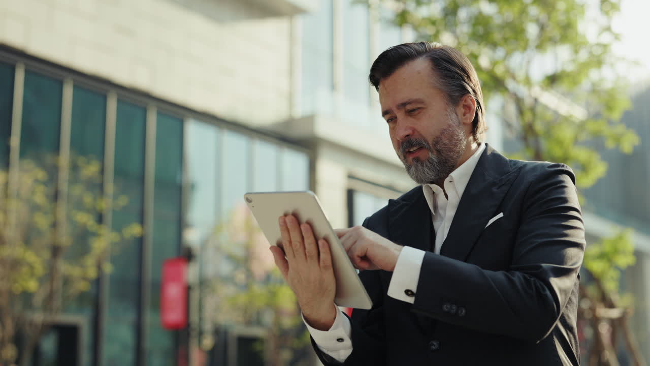 Empresário Sorridente Usando Tablet Digital ao Ar Livre em Frente a um Edifício Moderno