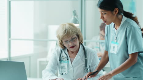 hispanic nurse working with senior caucasian doctor in clinic